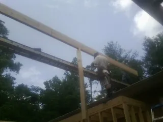 Carpenter setting a ridge beam over a new addition frame — Ice Dam Removal by Roofing Brothers in Gary